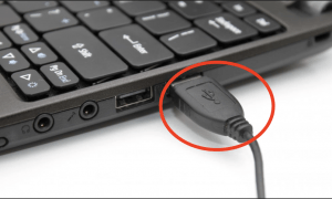Picture of a laptop with a USB cable pluged in and circled in red.
